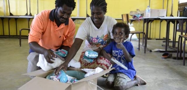 Gideon Iamar, 27 with wife Aileen, 26 and son John, 5 receive an Oxfam hygiene kit