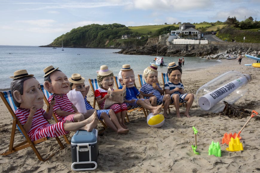 Oxfam campaigners pose as G7 leaders on Swanpool Beach near Falmouth