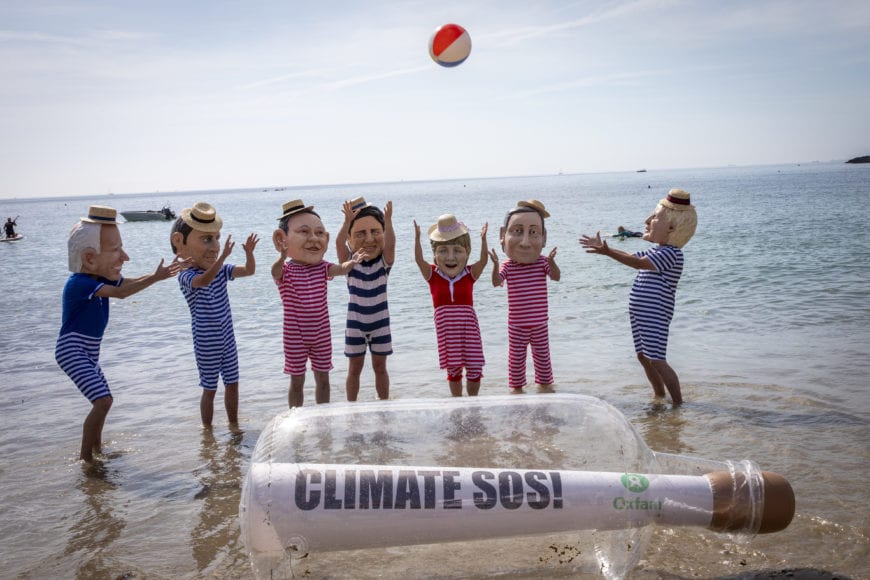 Oxfam campaigners pose as G7 leaders on Swanpool Beach near Falmouth