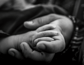 Black and white image of two hands being held