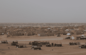 Sahrawi refugee camp, with beige sand and a muted blue sky
