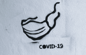 Image of a stencil of a mask with test 'COVID-19'