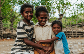 A mother is hugged by her two young children