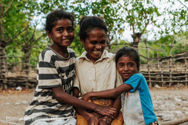 A mother is hugged by her two young children