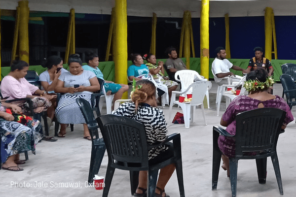 A group of people sit around in a circle at a community meeting