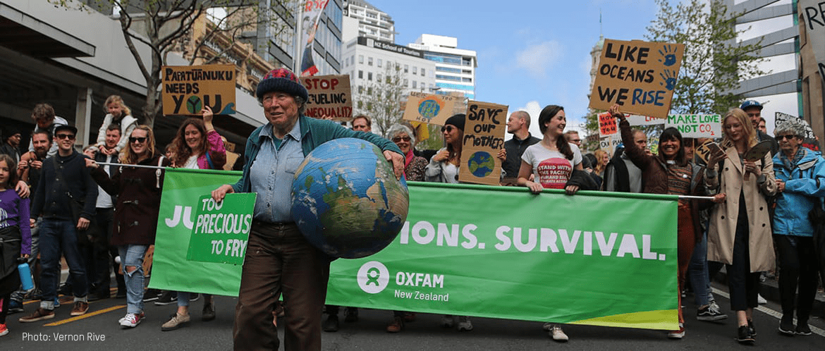 Image from a climate march, with protestors holding signs and a globe