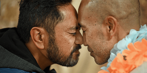 Two men embrace with a hongi