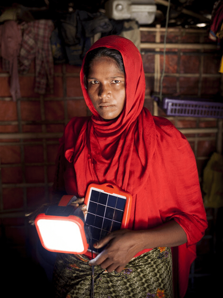 A woman wearing red holds a solar-powered light