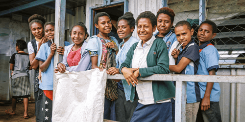 A group of children stand outside a health clinic