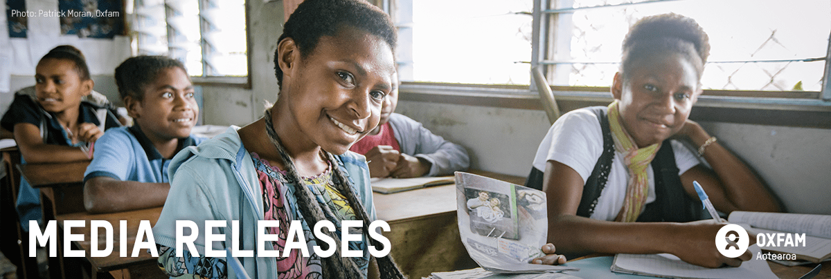 Children in a classroom, smiling at the camera with text 'media releases'