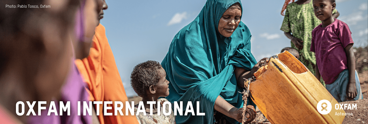 Children gather around a woman collecting water