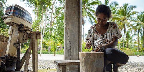 A woman hammers shells