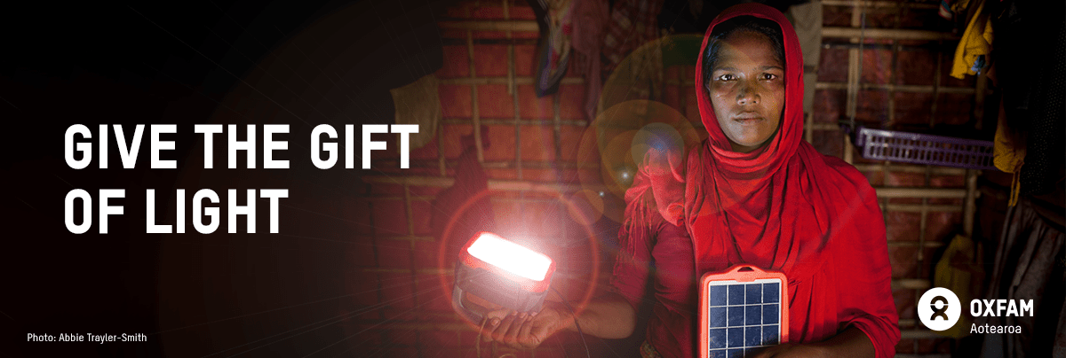 Asia holds a solar powered lantern in her hand with text 'give the gift of light'