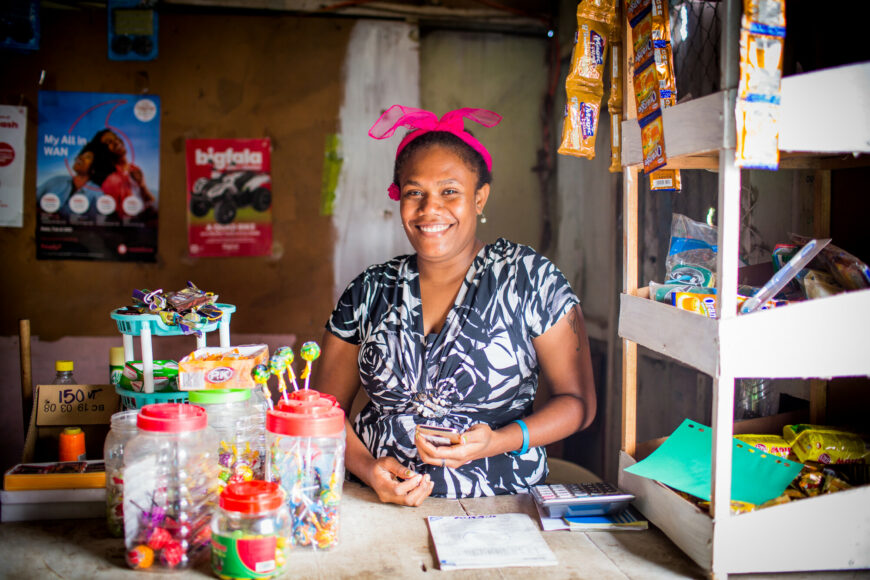 A woman smiling behind a shop counter