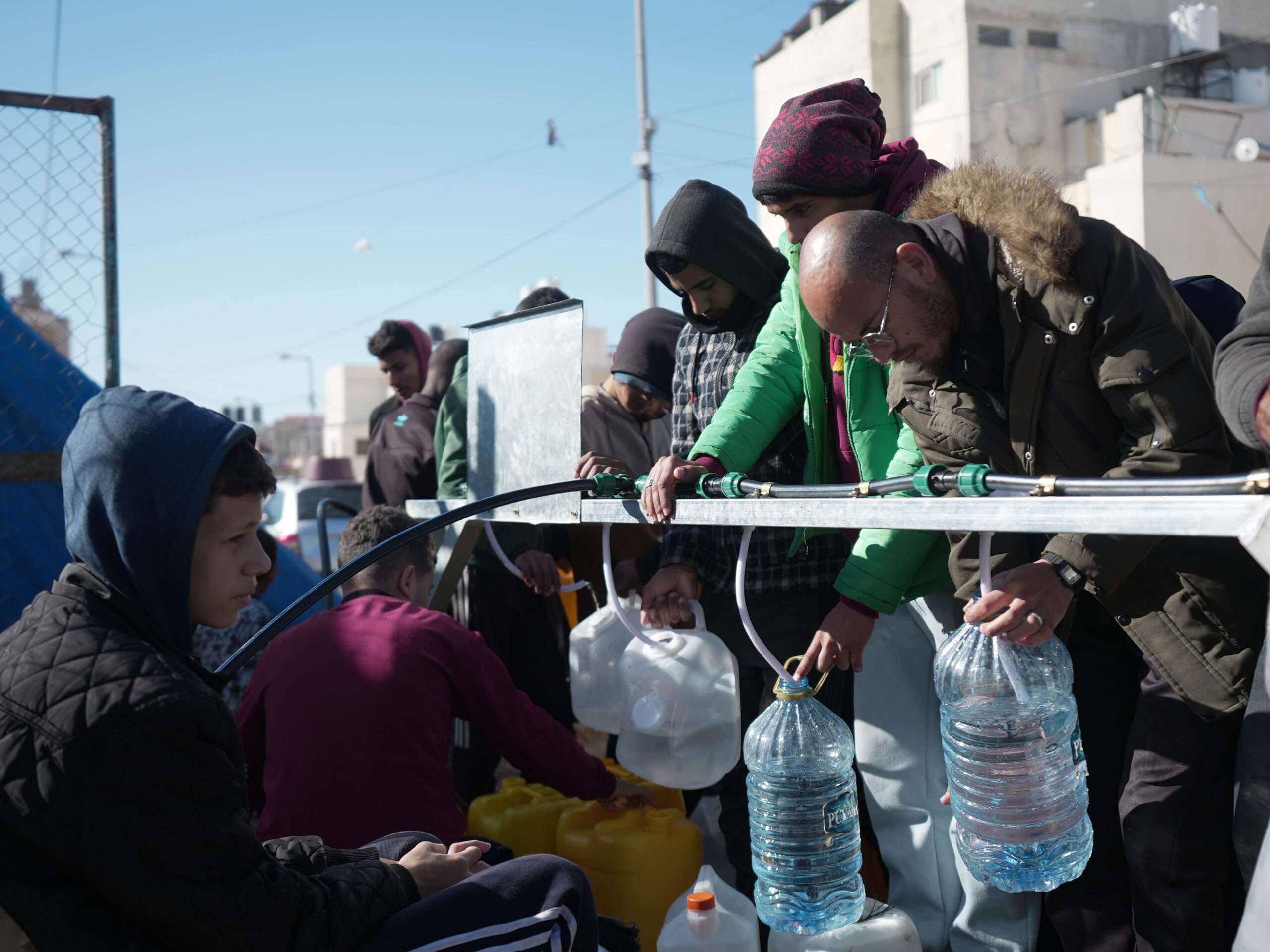 people in Gaza filling up water bottles