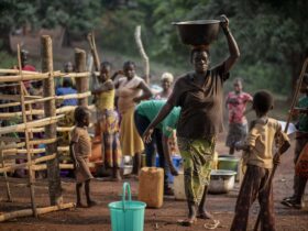 Woman carrying bucket of water on head
